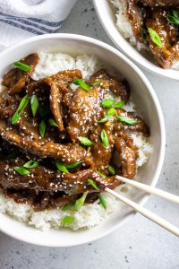 Easy Mongolian Beef recipe is a perfect quick 30 minutes dinner, made with crispy thinly sliced flank steak and coated with sweet and spicy sauce.