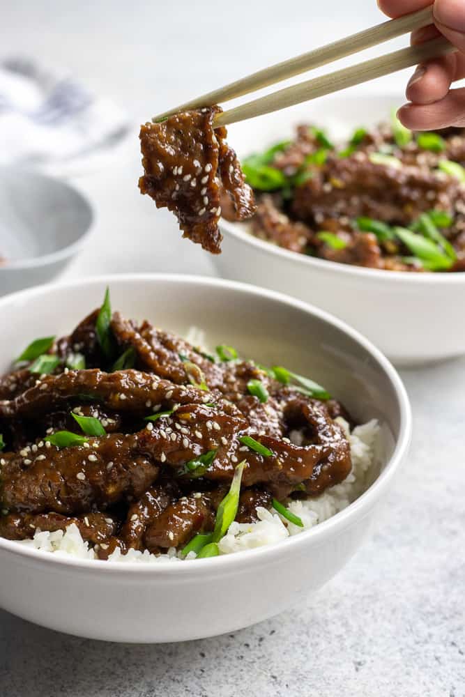 Easy Mongolian Beef recipe is a perfect quick 30 minutes dinner, made with crispy thinly sliced flank steak and coated with sweet and spicy sauce.