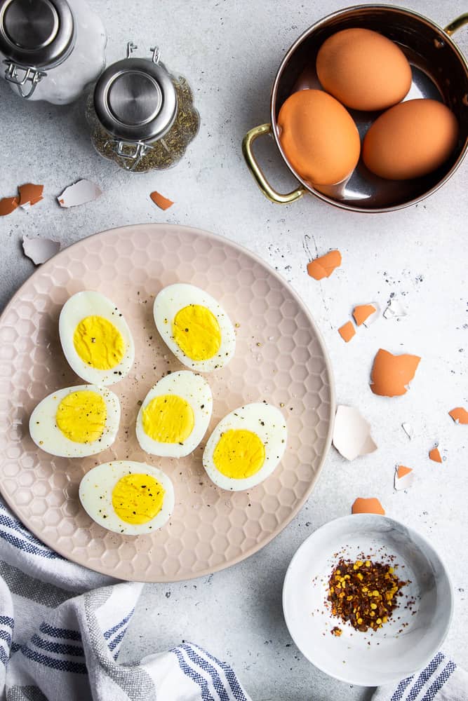Instant Pot Hard Boiled Eggs, peeled and cut in halves on a plate.