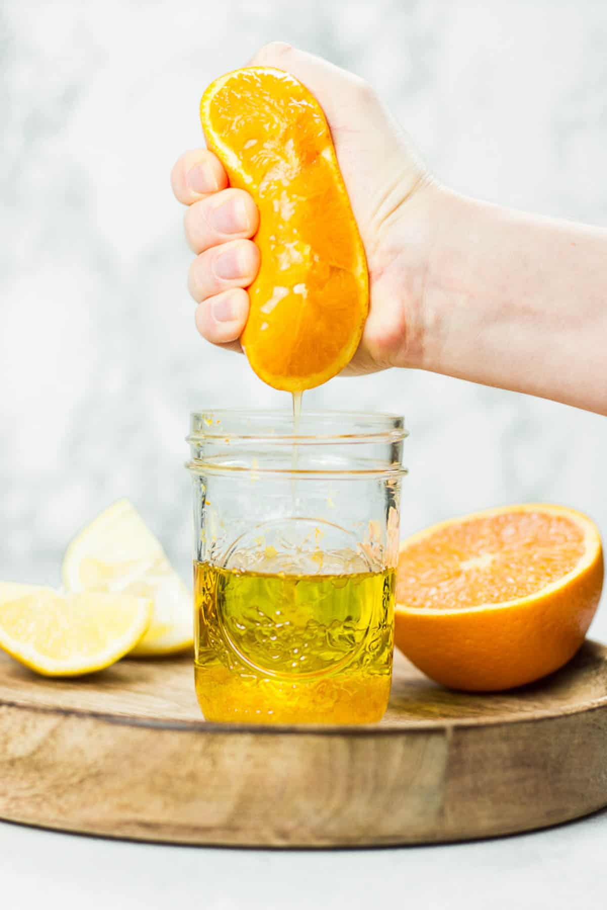 Squeezing orange juice in mason jar.