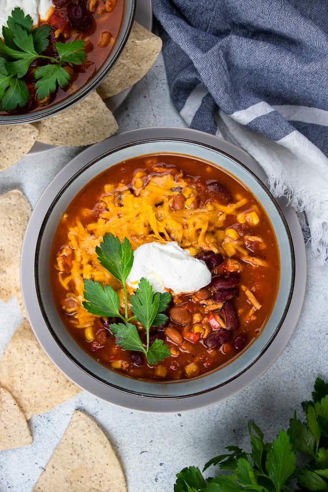 Instant Pot Turkey Chili topped with cheddar cheese, sour cream, and cilantro.