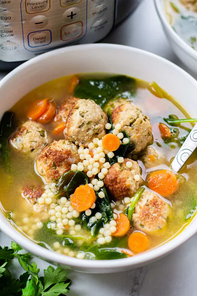 Italian Wedding Soup turkey with meatballs, acini de pepe pasta, and spinach in a white bowl.