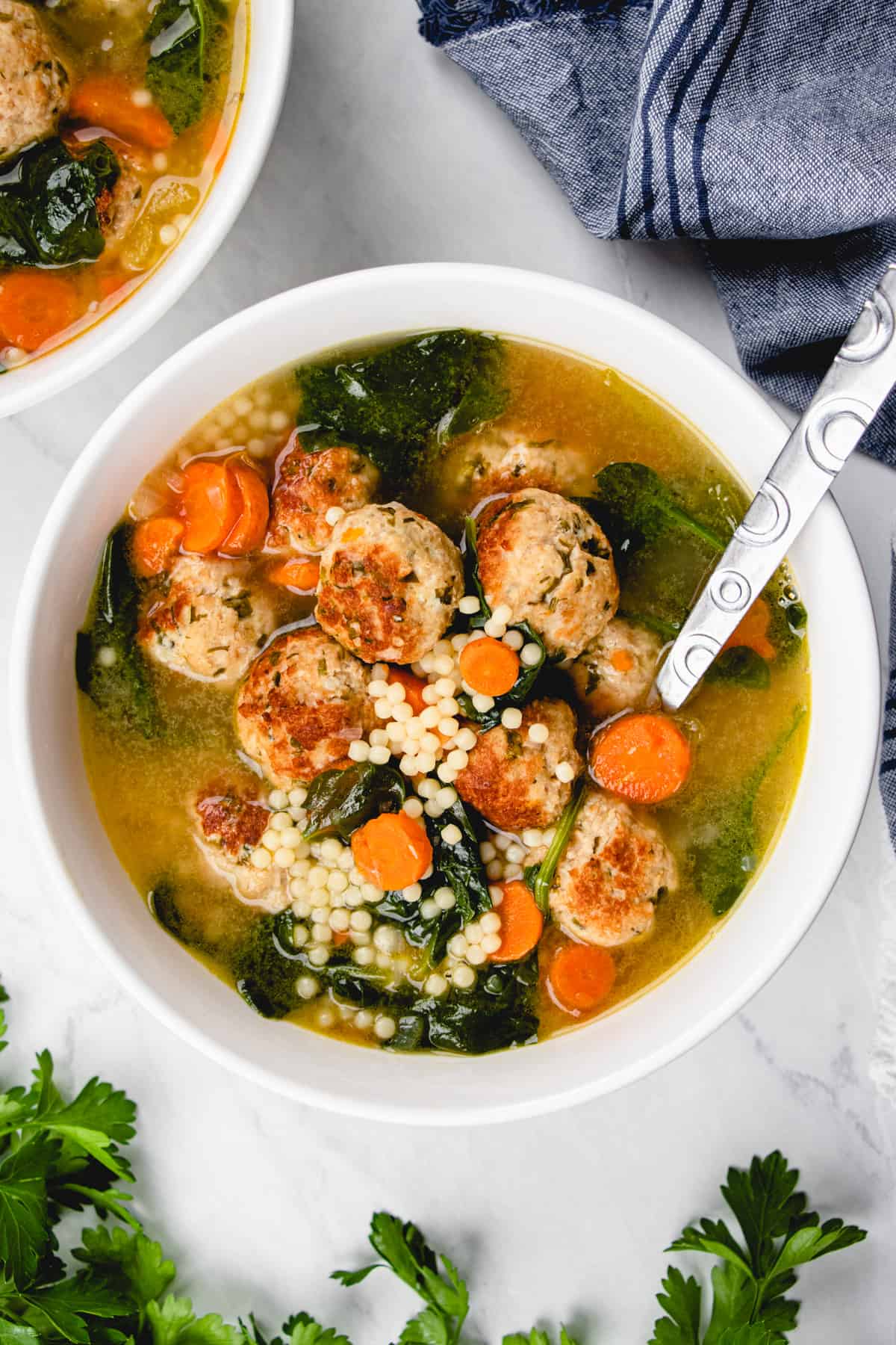 Italian Wedding Soup turkey with meatballs, acini de pepe pasta, and spinach in a white bowl.