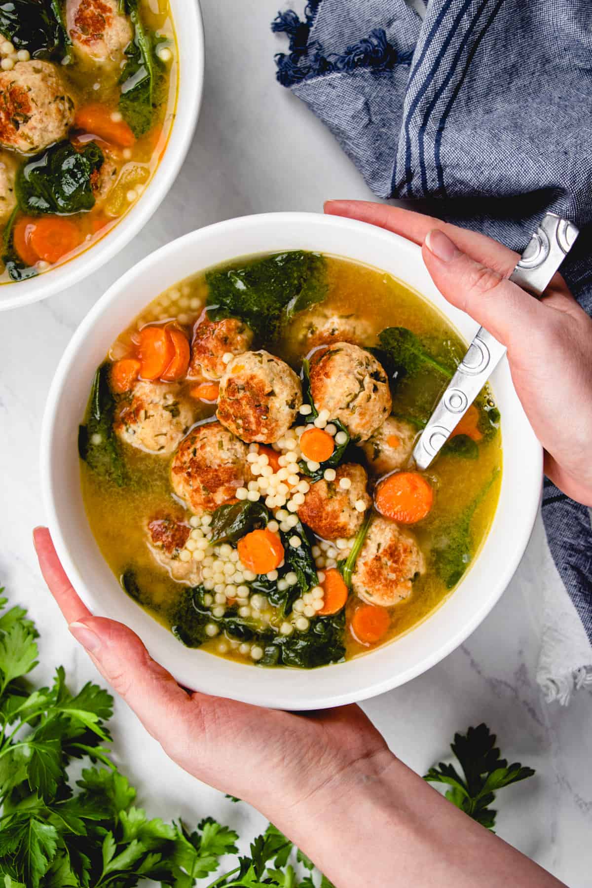 Italian Wedding Soup turkey with meatballs, acini de pepe pasta, and spinach in a white bowl.