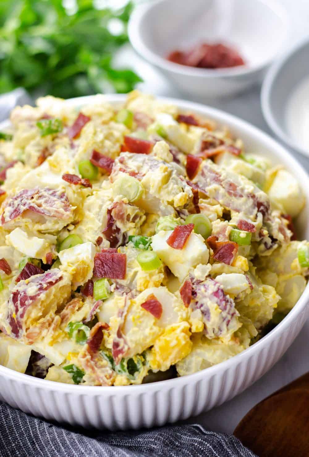 Potato Salad with Bacon and Egg in a white bowl.
