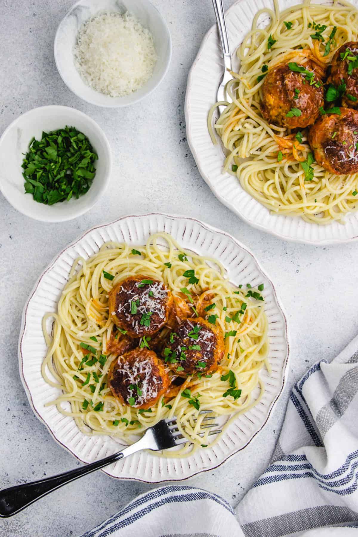 Turkey meatballs, served with spaghetti on a white plate.