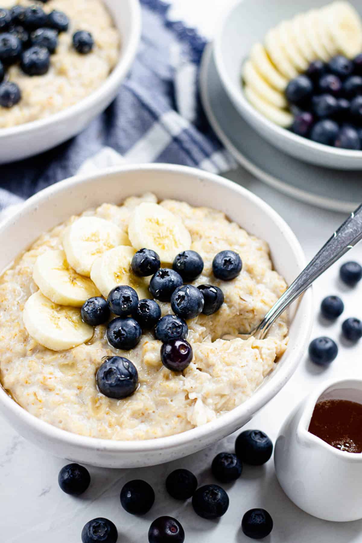 Oatmeal, topped with banana and blueberries in a bowl.