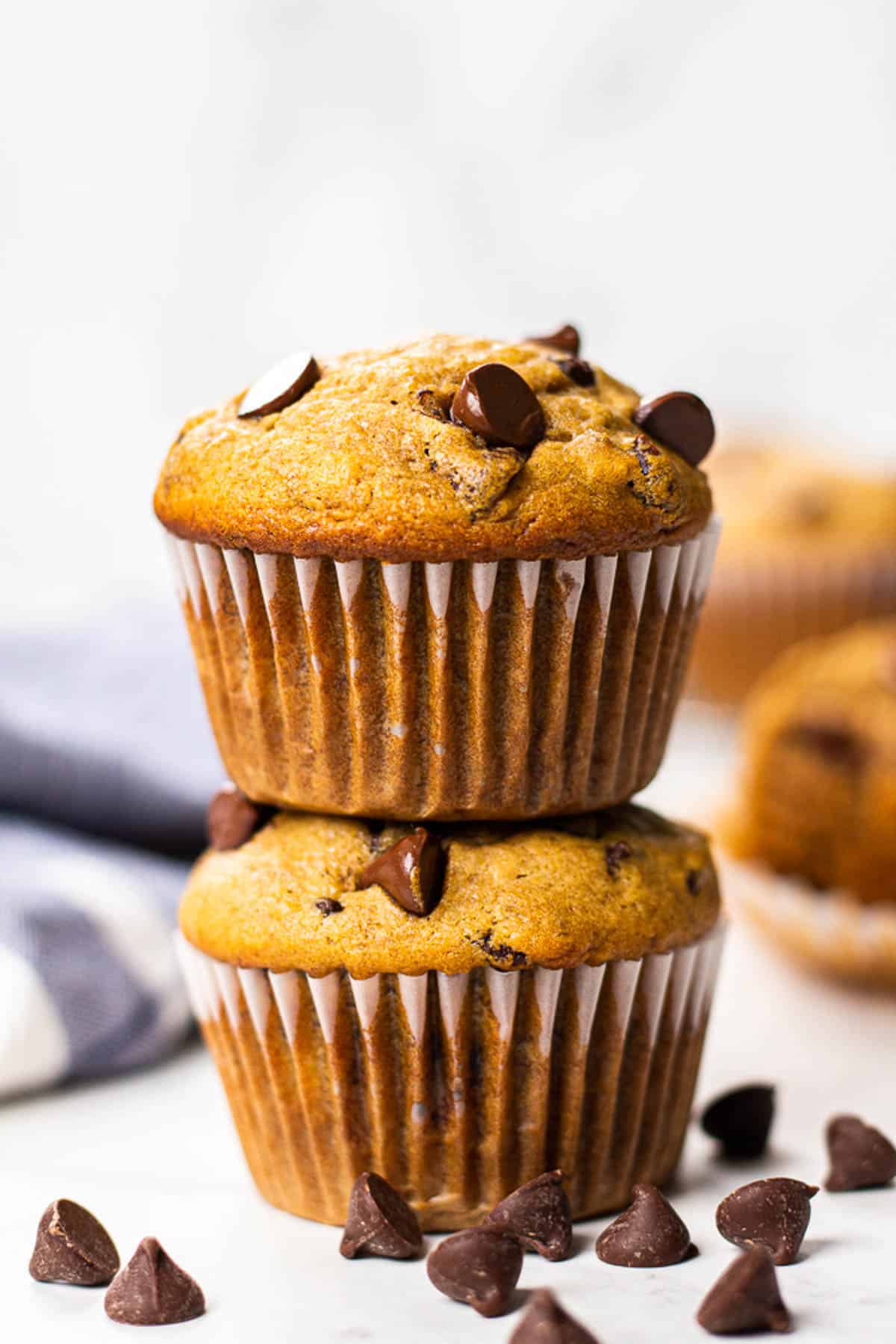 Two Banana Chocolate Chip Muffins on a table.