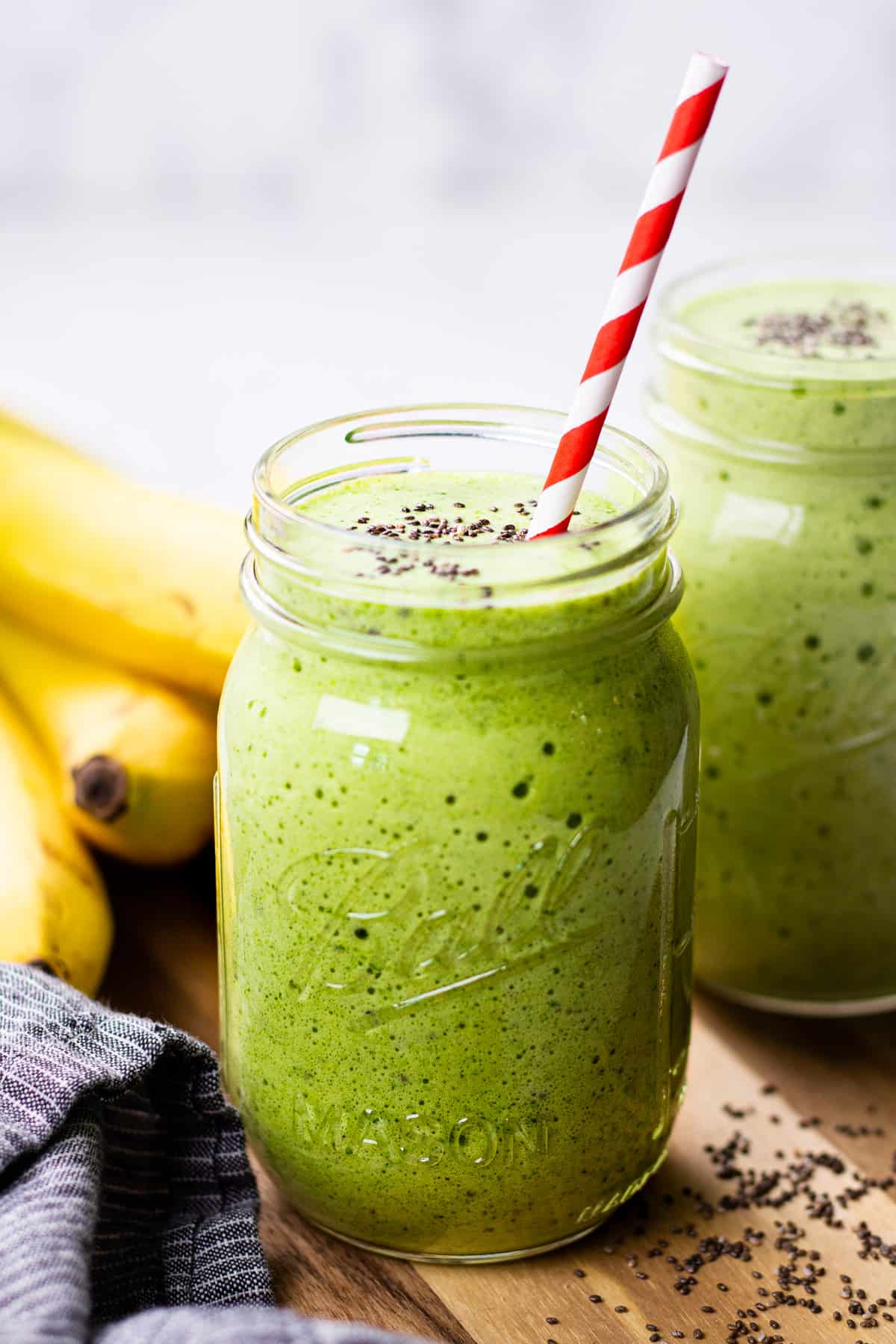 A close up photo of a green smoothie in a Mason jar.