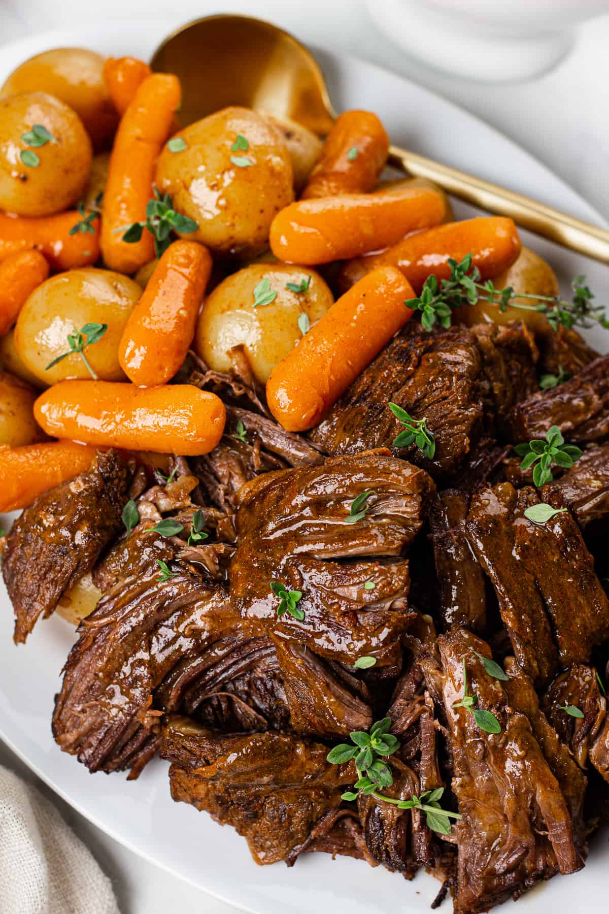 Pot Roast with potatoes and carrots served on a white plate.