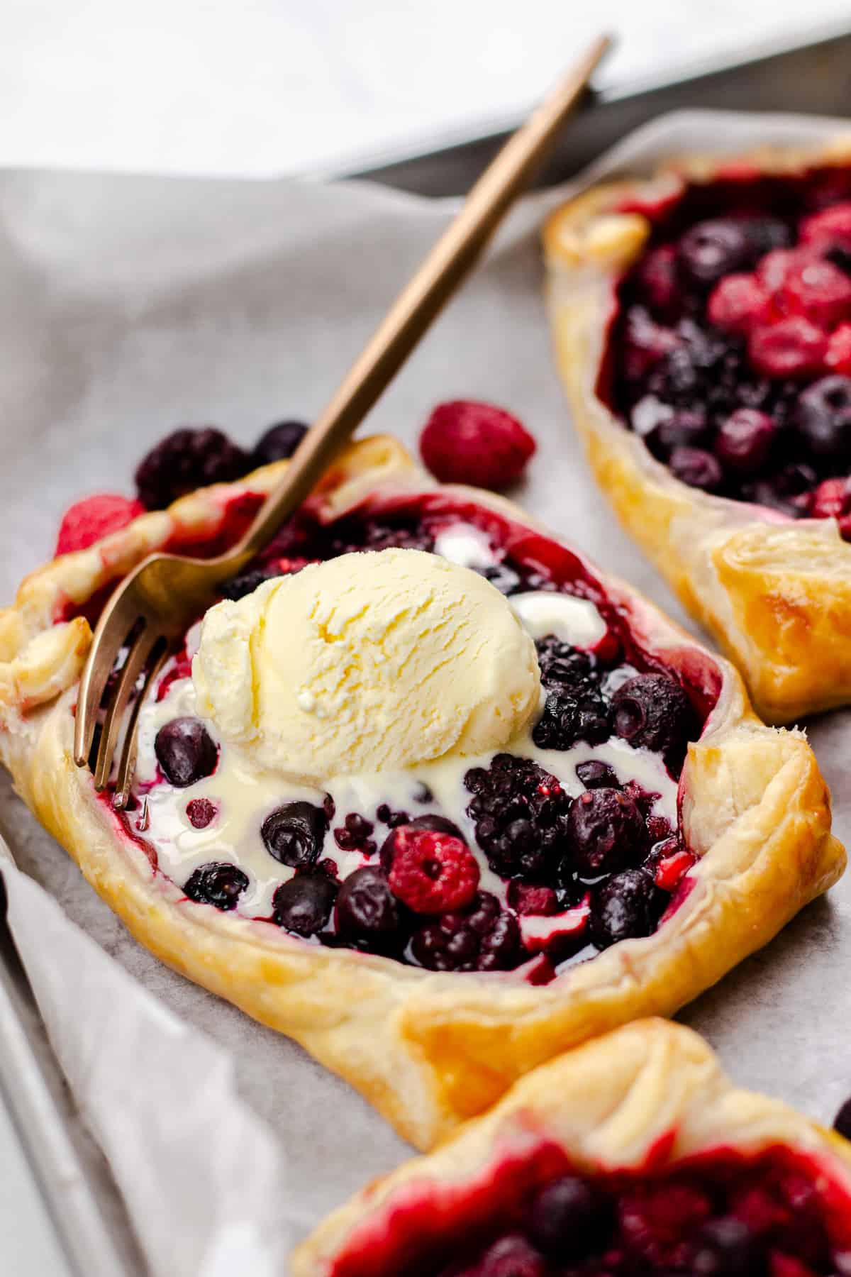 Mixed Berry Puff Pastry Tarts, topped with vanilla ice cream.