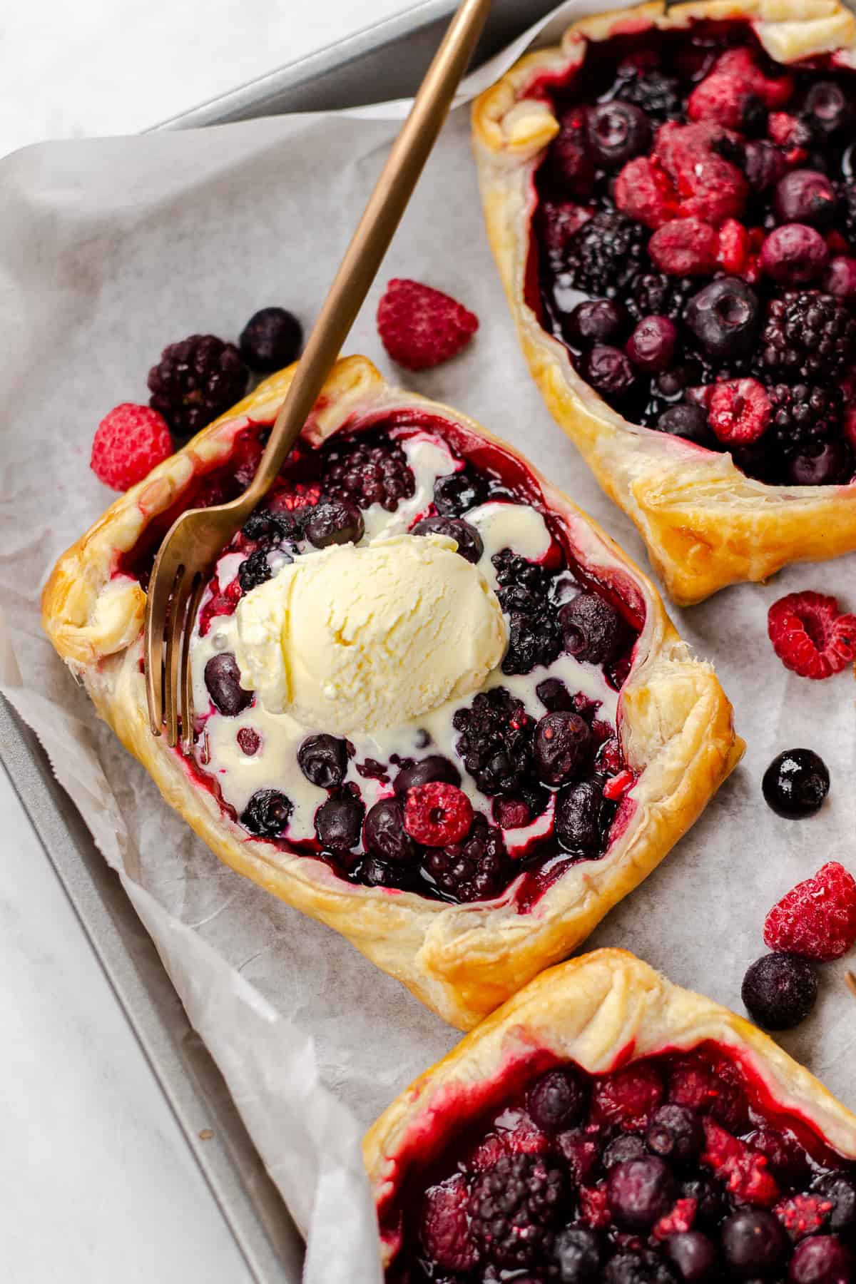 Mixed Berry Puff Pastry Tarts, topped with vanilla ice cream.