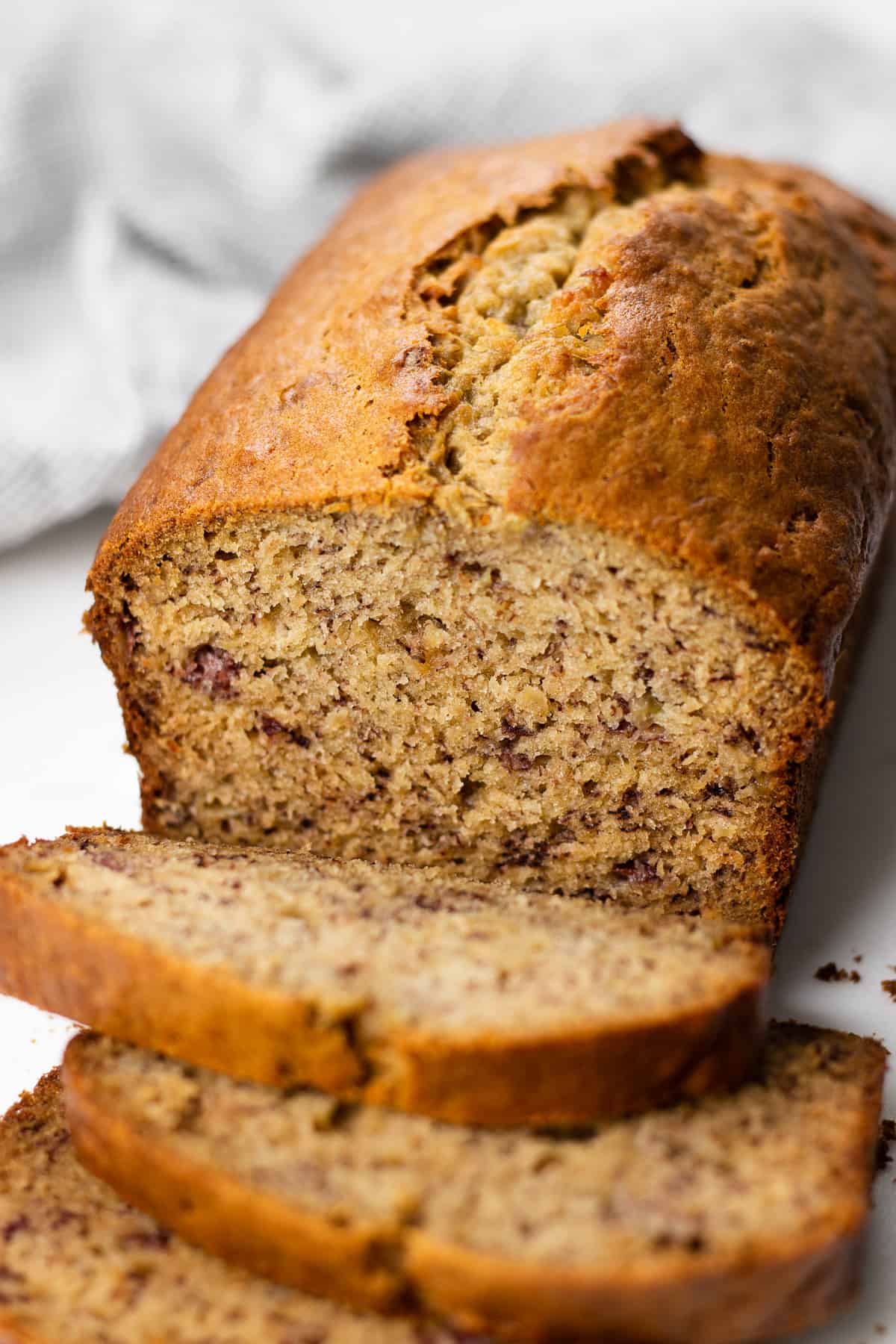 Sliced banana bread on a white table.