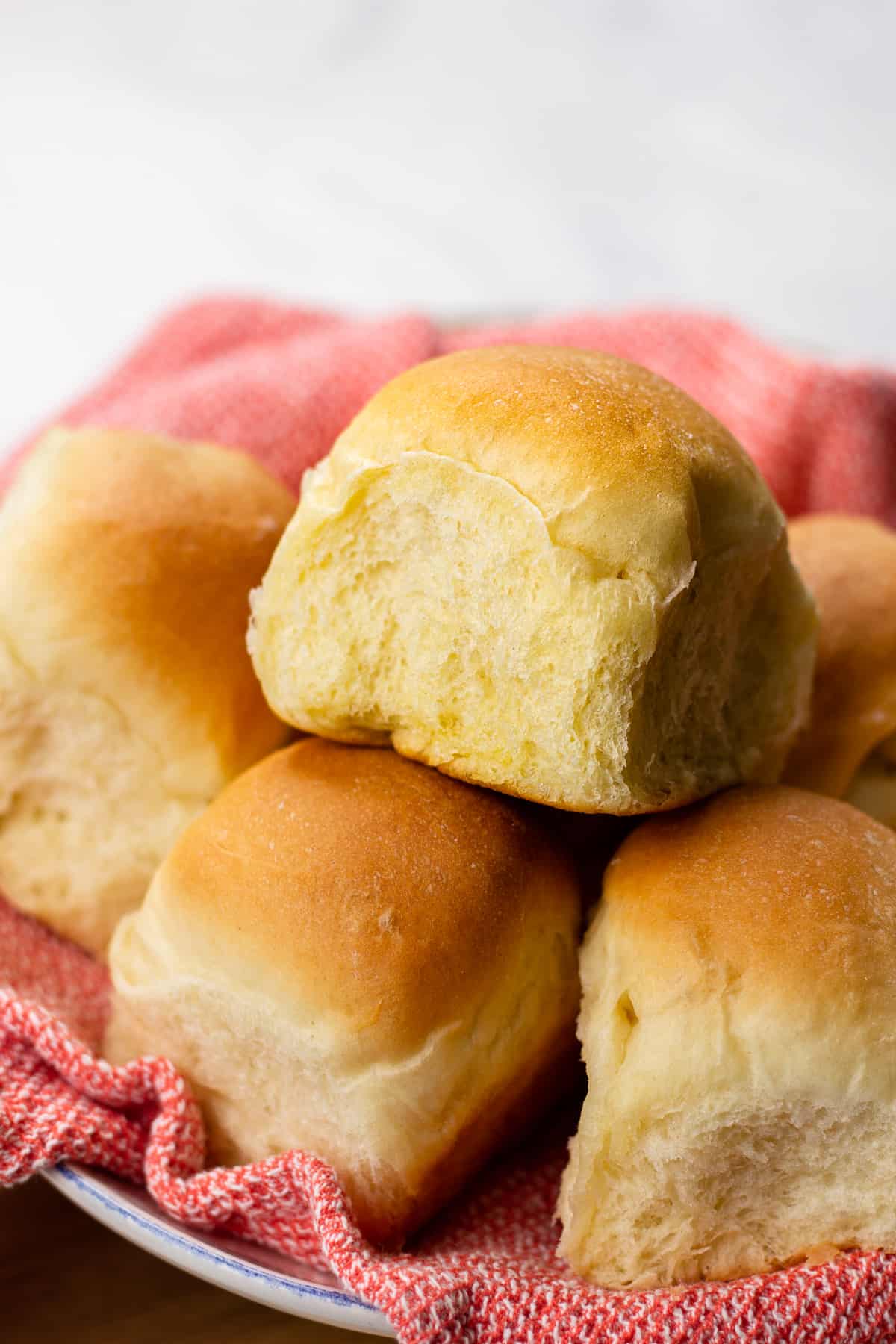 Dinner rolls on a red kitchen towel.