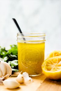 Lemon Vinaigrette in a mason jar and ingredients around.