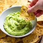 Dipping a tortilla chip in avocado dip.