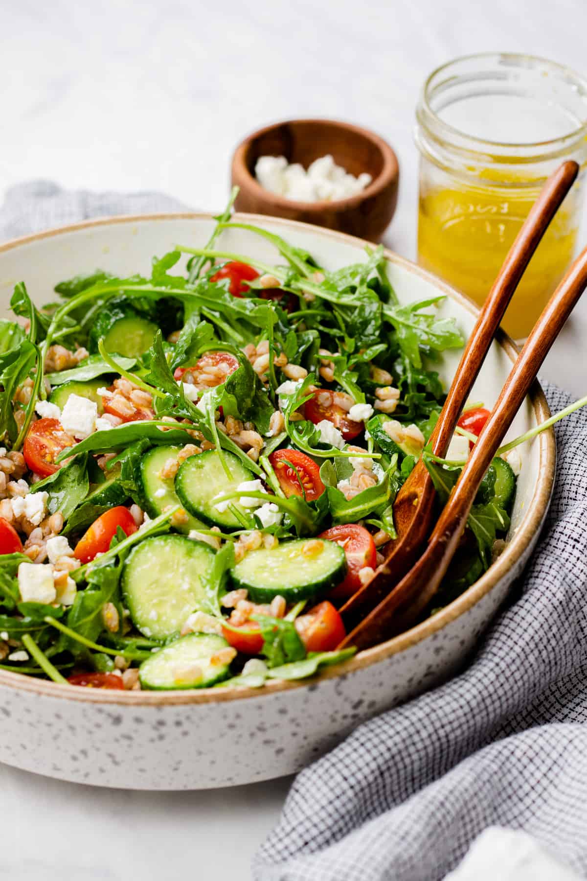 Farro salad with arugula, cucumbers, and tomatoes in a bowl.