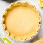 Unbaked pie crust in a white round baking pan.