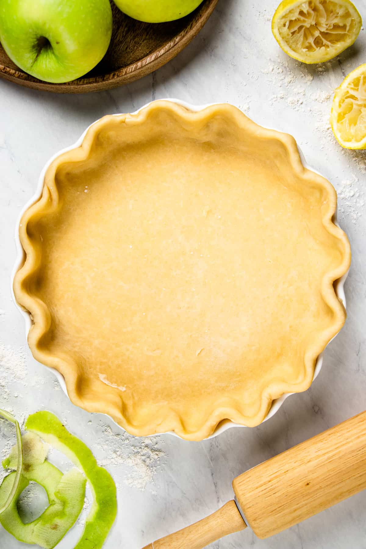 Unbaked pie crust in a white round baking pan.
