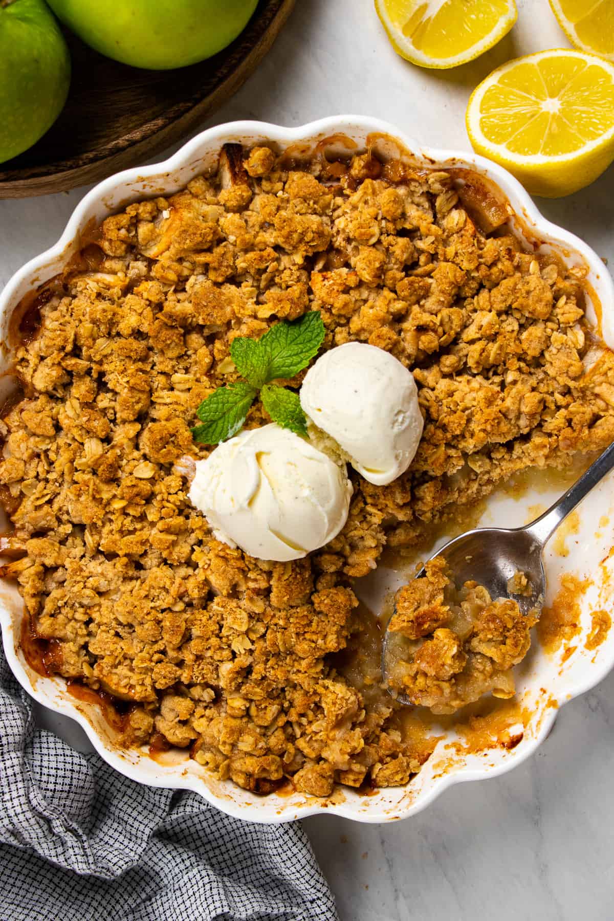 Overhead photos of apple crisp in a white baking pan with a scoop of ice cream on top.