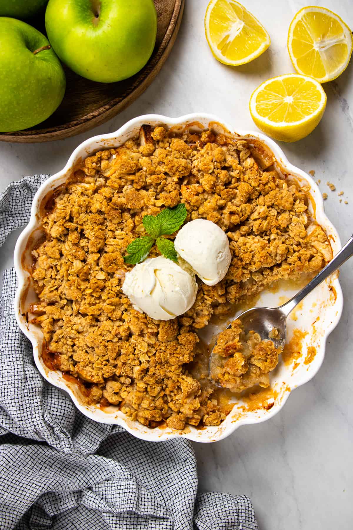 Overhead photos of apple crisp in a white baking pan with a scoop of ice cream on top.