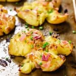 Baked smashed potatoes topped with bacon and chives.