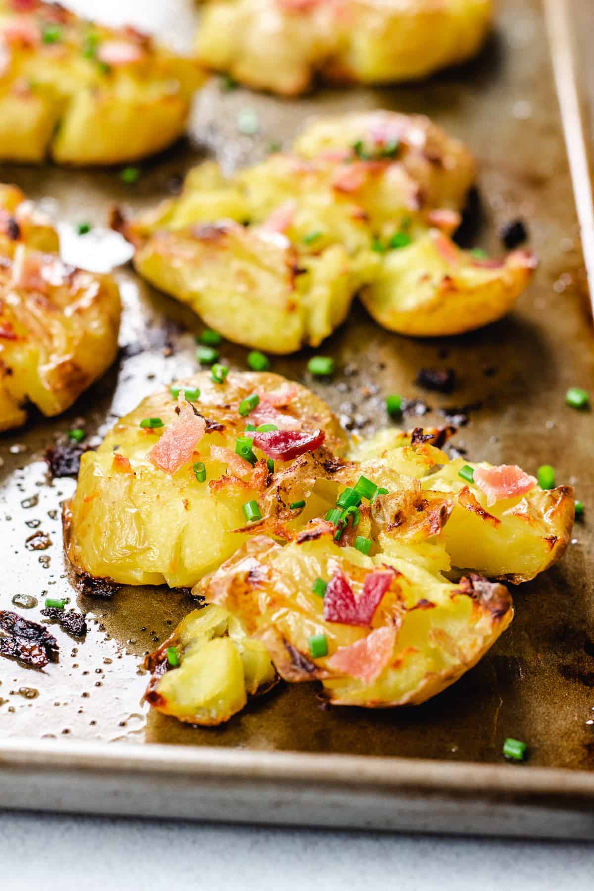 Baked smashed potatoes topped with bacon and chives.