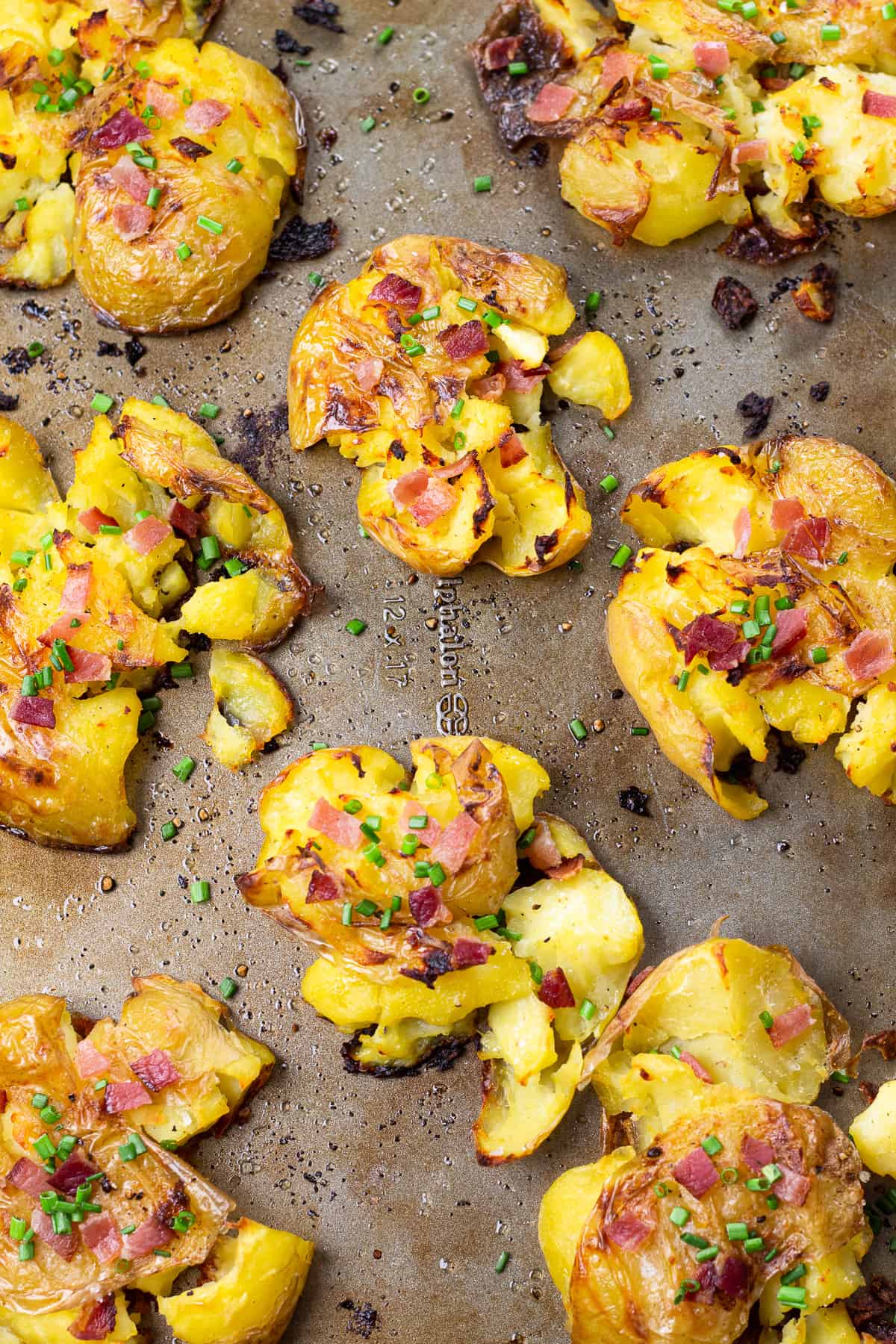Baked smashed potatoes topped with bacon and chives.