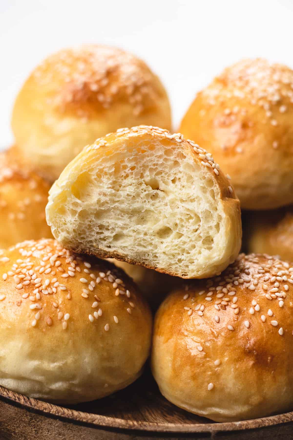 A close up photo of potato rolls topped with sesame seeds.