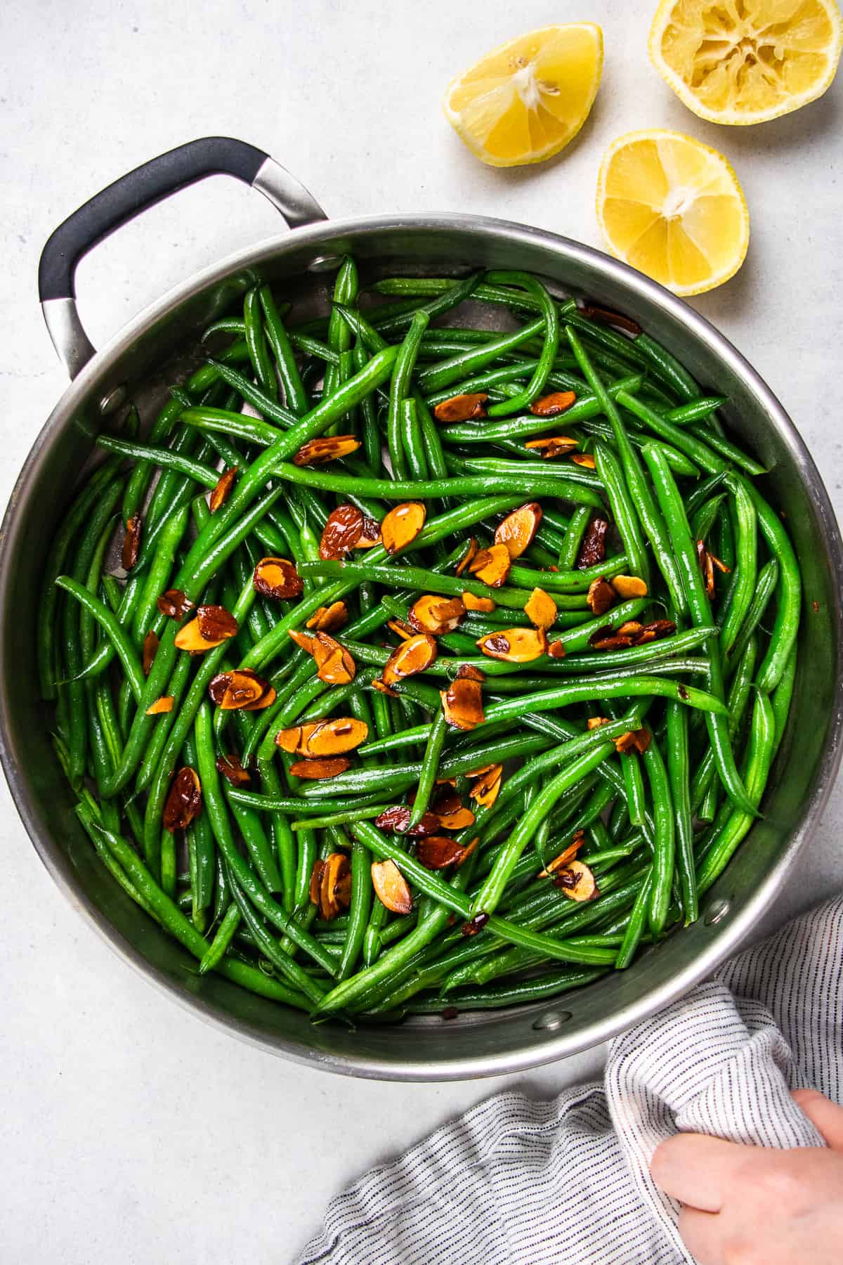 Green beans amandine topped with toasted alonds in a skillet.