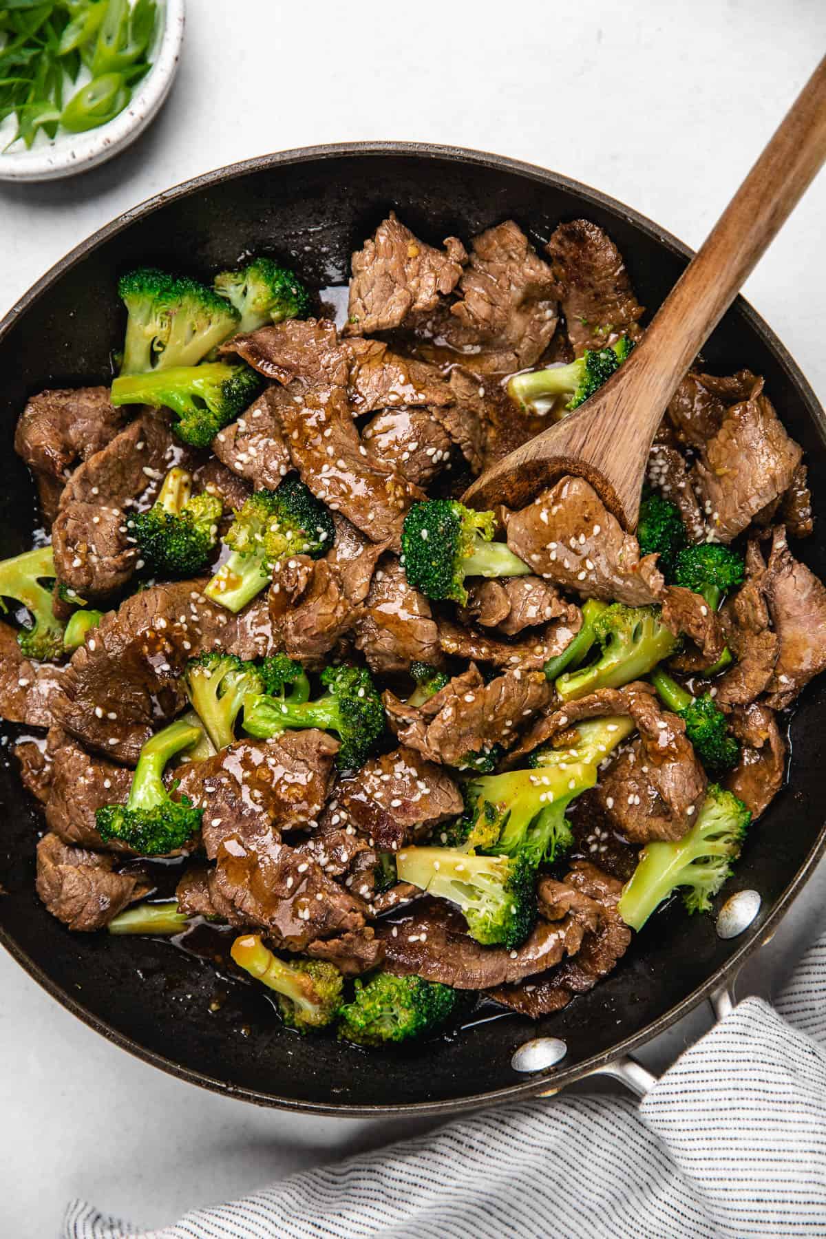 Beef and Broccoli in a skillet, topped with sesame seeds.