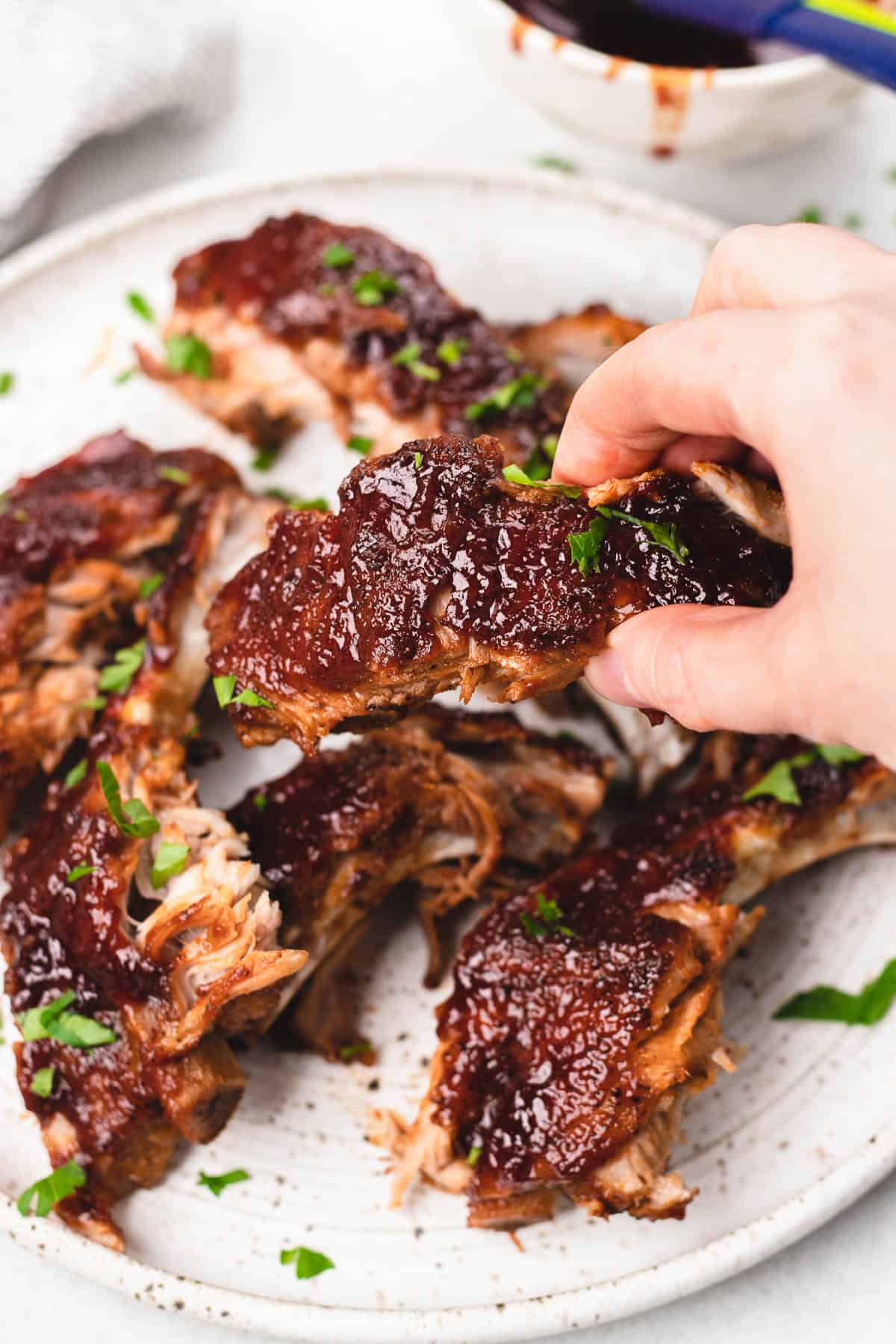 Precut BBQ Ribs on a white plate.