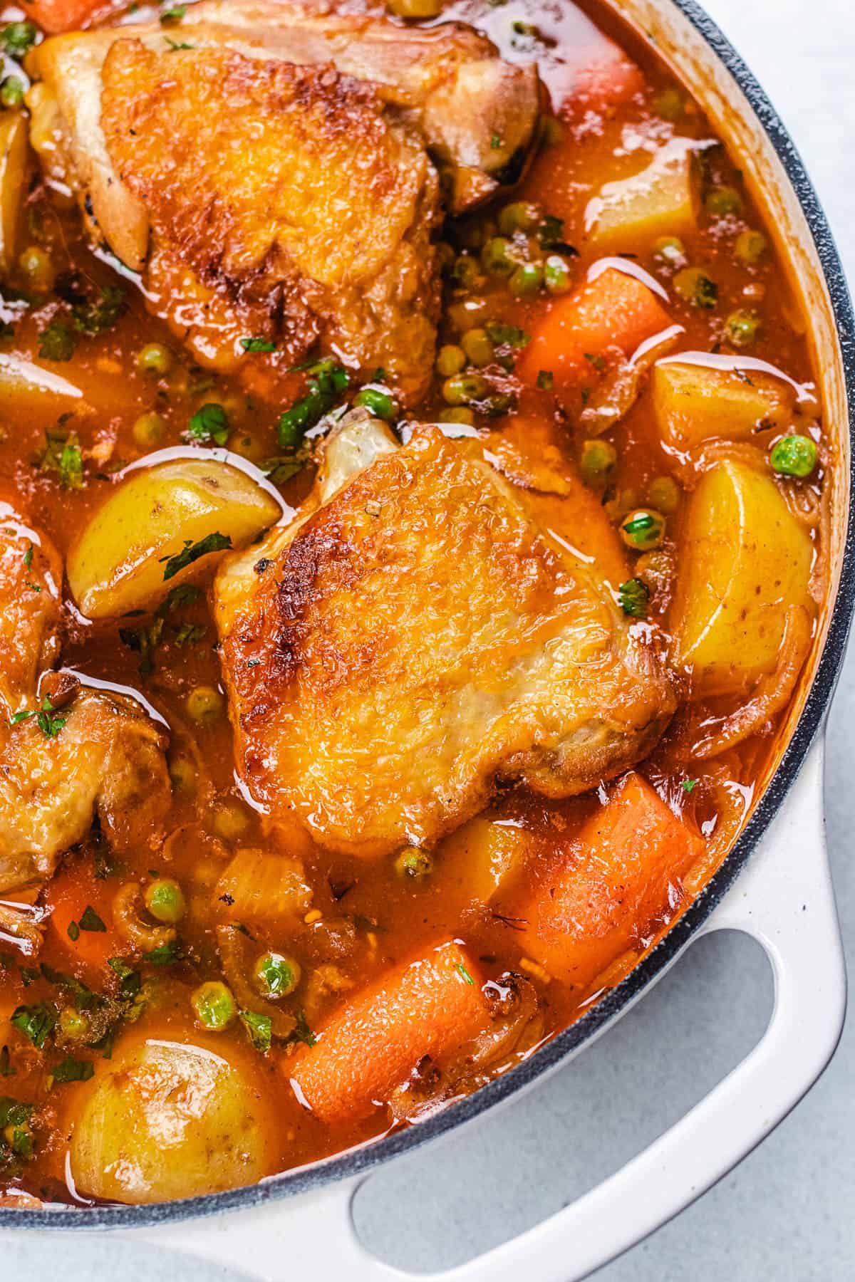 Chicken stew in a white casserole dish.