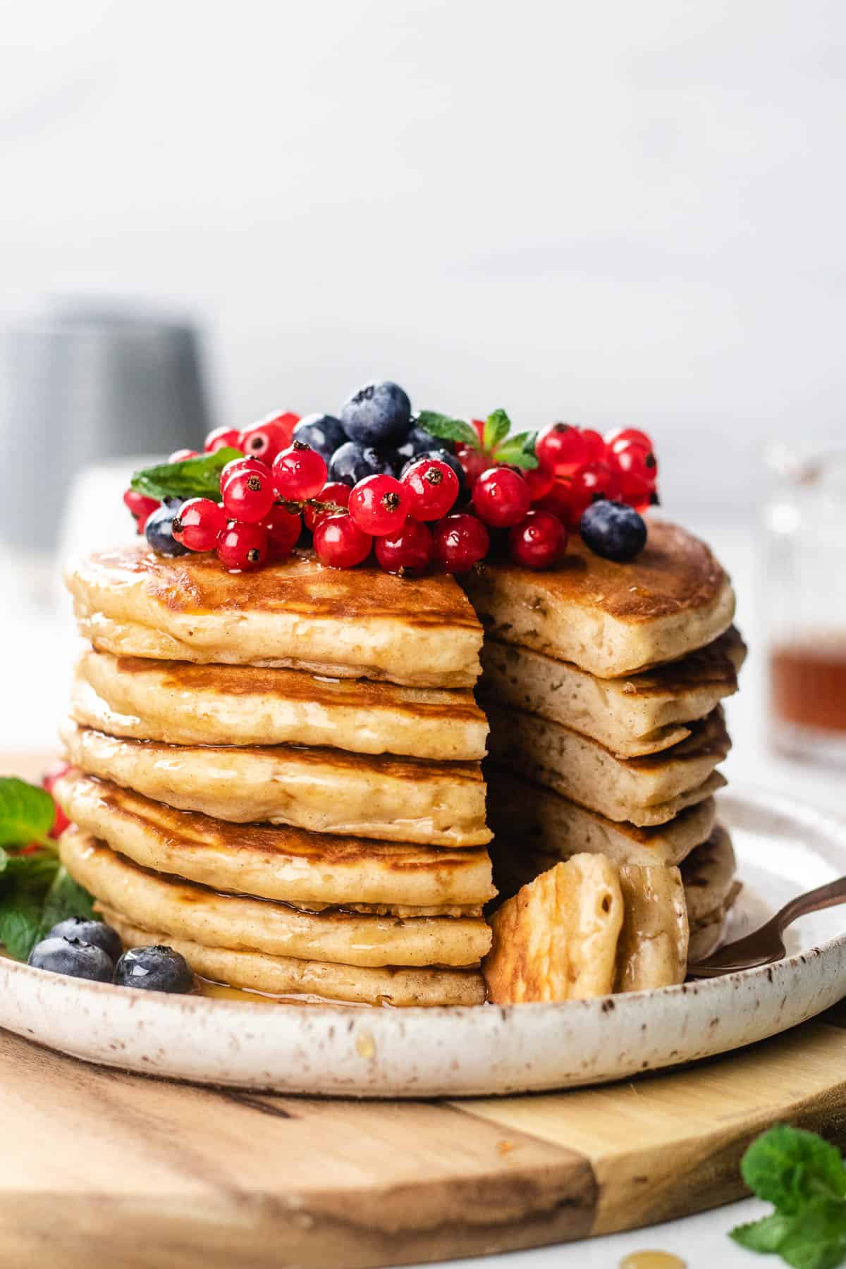 A stack of pancakes, topped with berries on a plate.