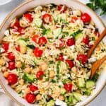Salad with orzo, cucumbers, cherry tomatoes in a large bowl.