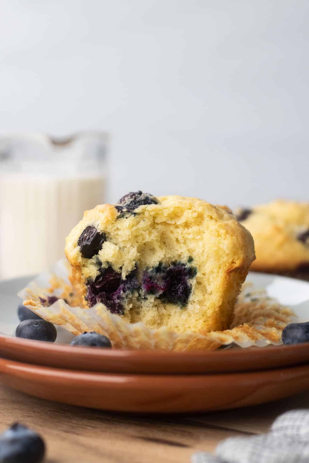 A bite shot of a blueberry muffins on a cutting board.