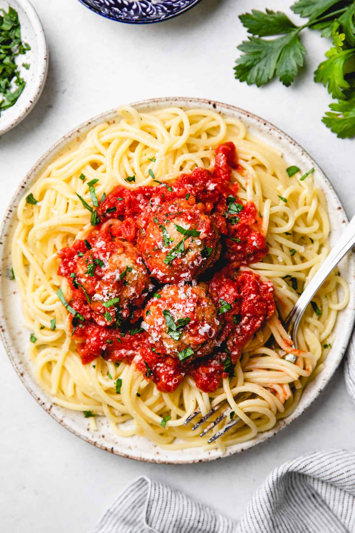 Meatballs with tomato sauce and spaghetti on a plate with a fork.