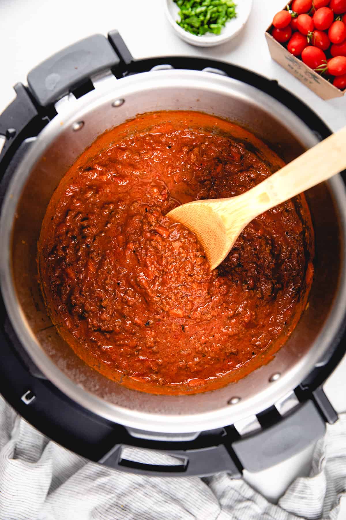 Bolognese sauce with a wooden spoon in Instant Pot.