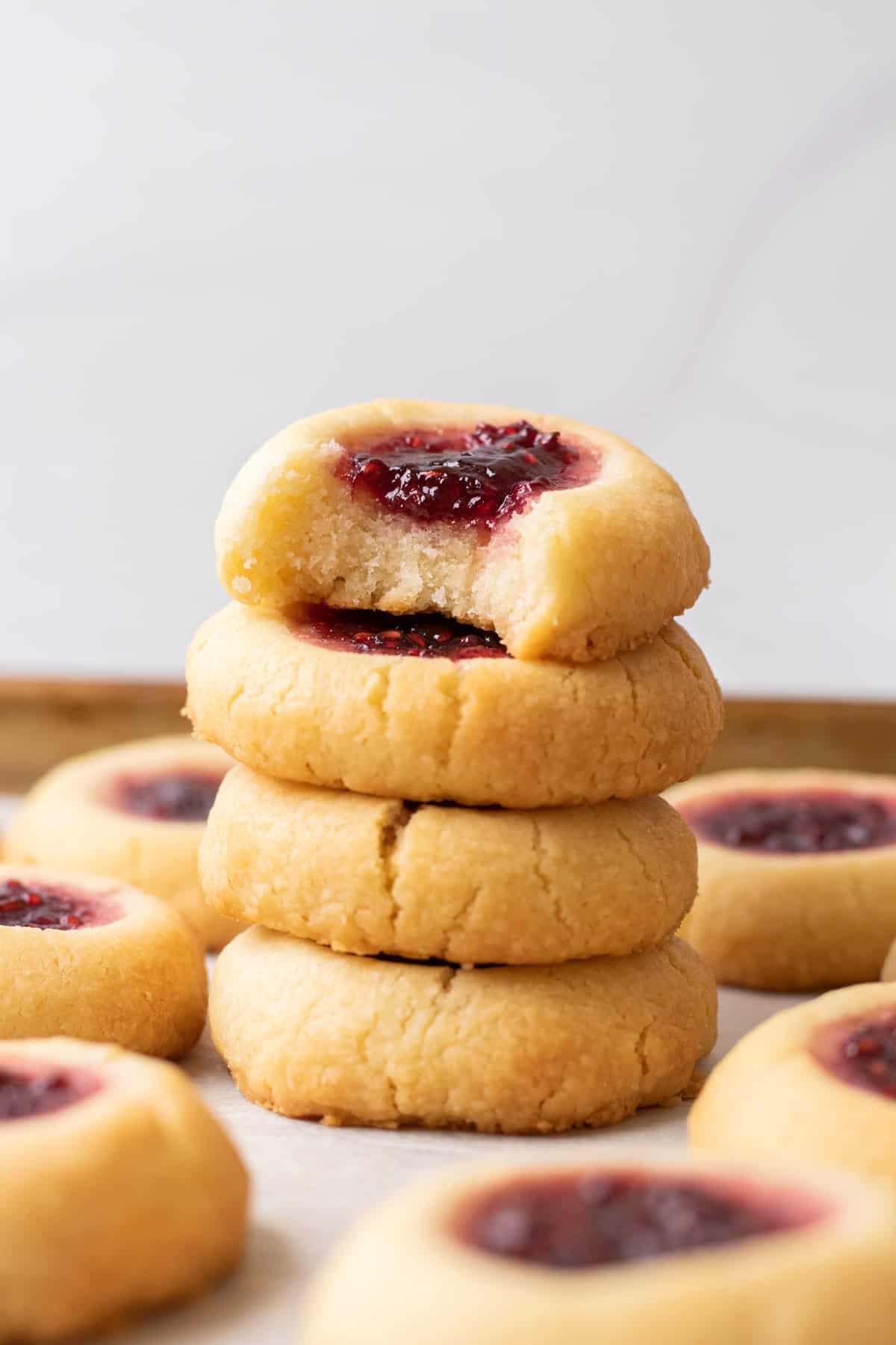 Raspberry Almond Thumbprint Cookies stacked on top of each other.