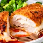 Breaded chicken breast, stuffed with melted mozzarella cheese, with tomato sauce and broccoli.