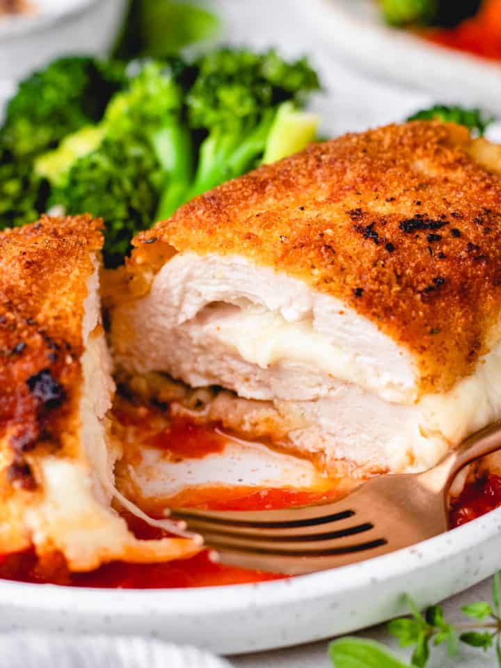 Breaded chicken breast, stuffed with melted mozzarella cheese, with tomato sauce and broccoli.