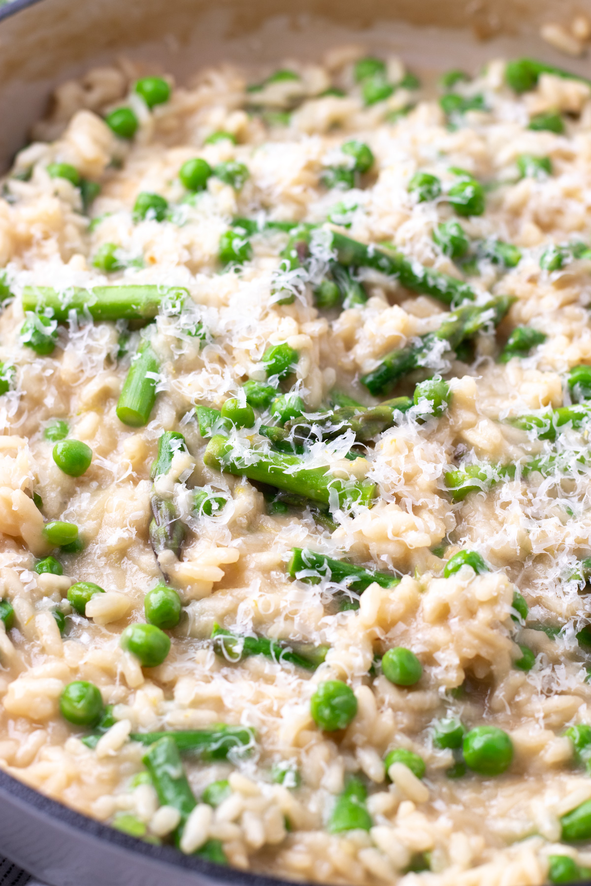 Risotto with peas and asparagus in a pot.