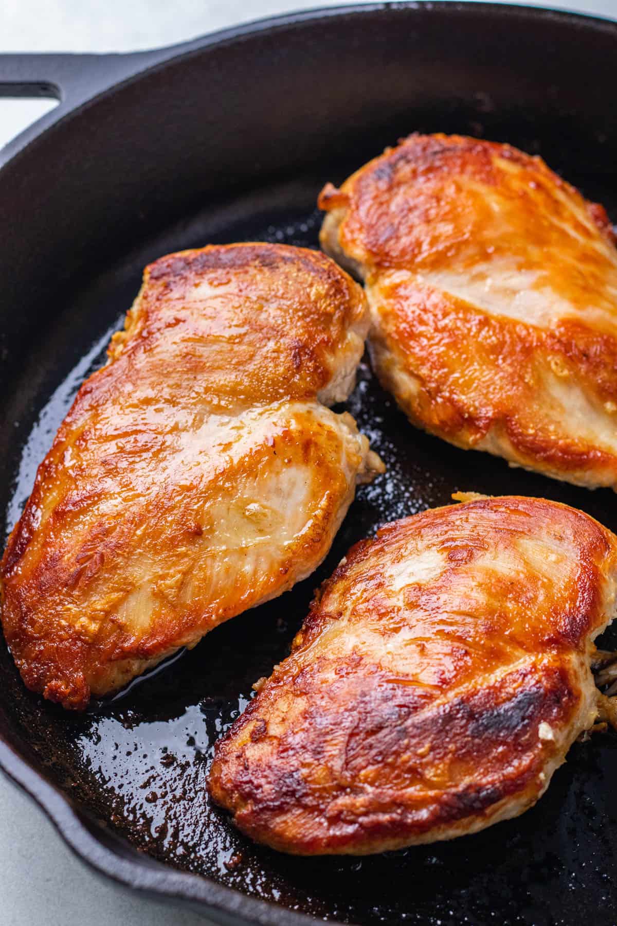 Seared chicken breasts in an cast iron skillet.