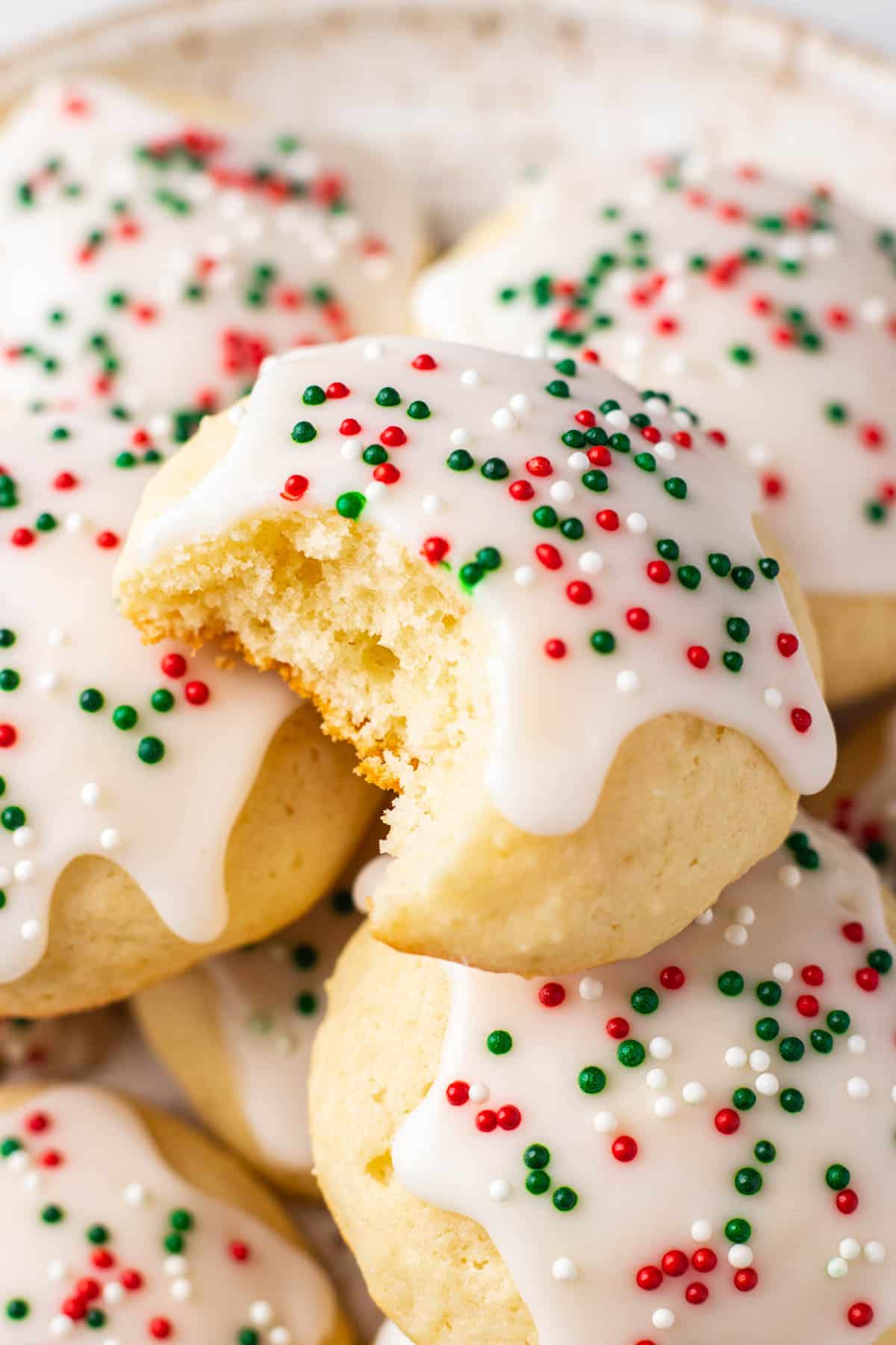 Sour Cream Cookies, topped with sugar icing and sprinkles on a plate.
