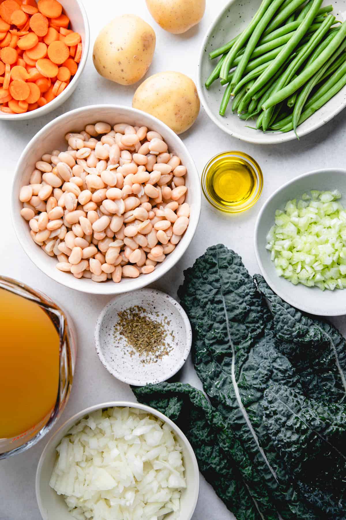 Separate ingredients to make white bean vegetable soup.