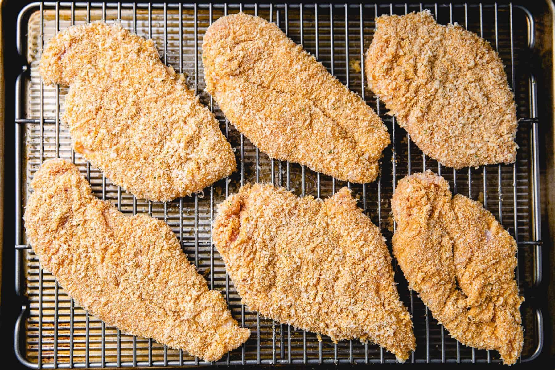 unbaked Chicken Cutlets on a bakich sheet.