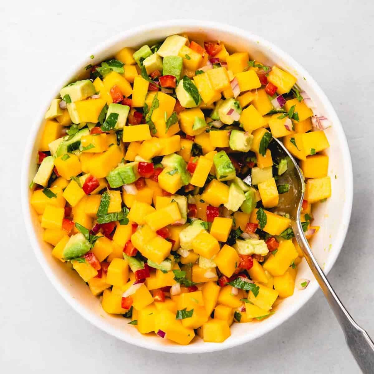 Mixing mango avocado salsa.