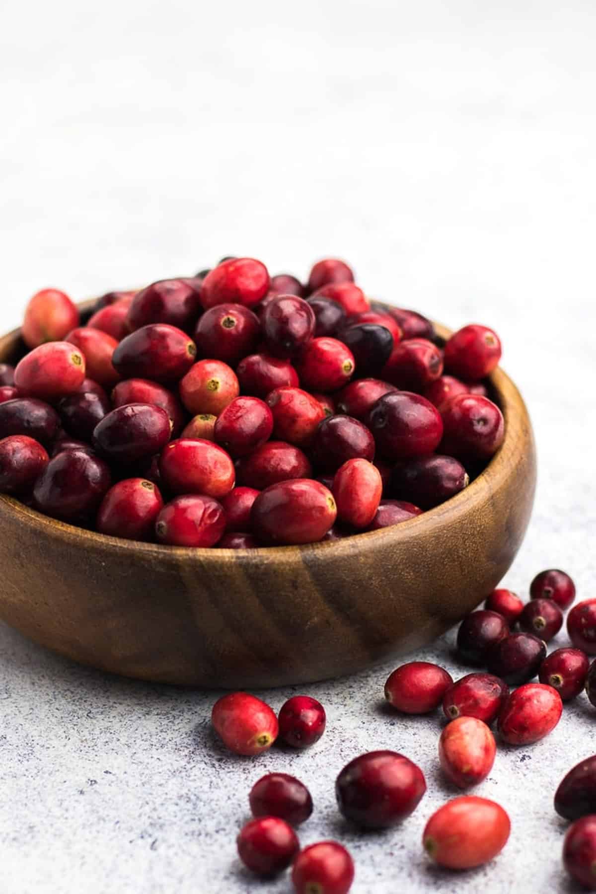 Fresh cranberries in a wooden bowl.